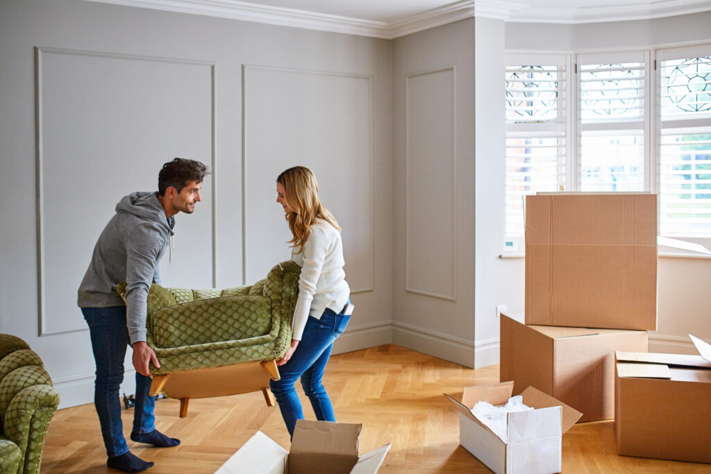 Shot of a young couple moving a couch